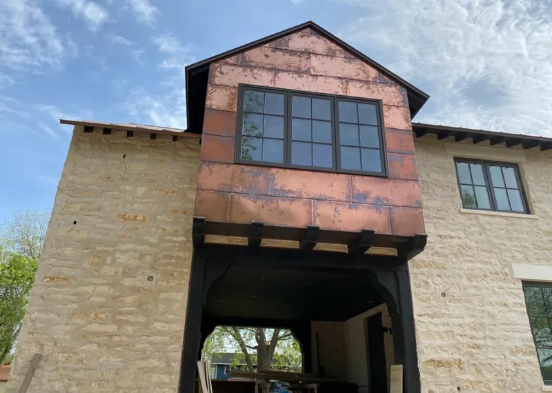 Copper metal panel facade on a stone building for Skylight Installation in Harrah